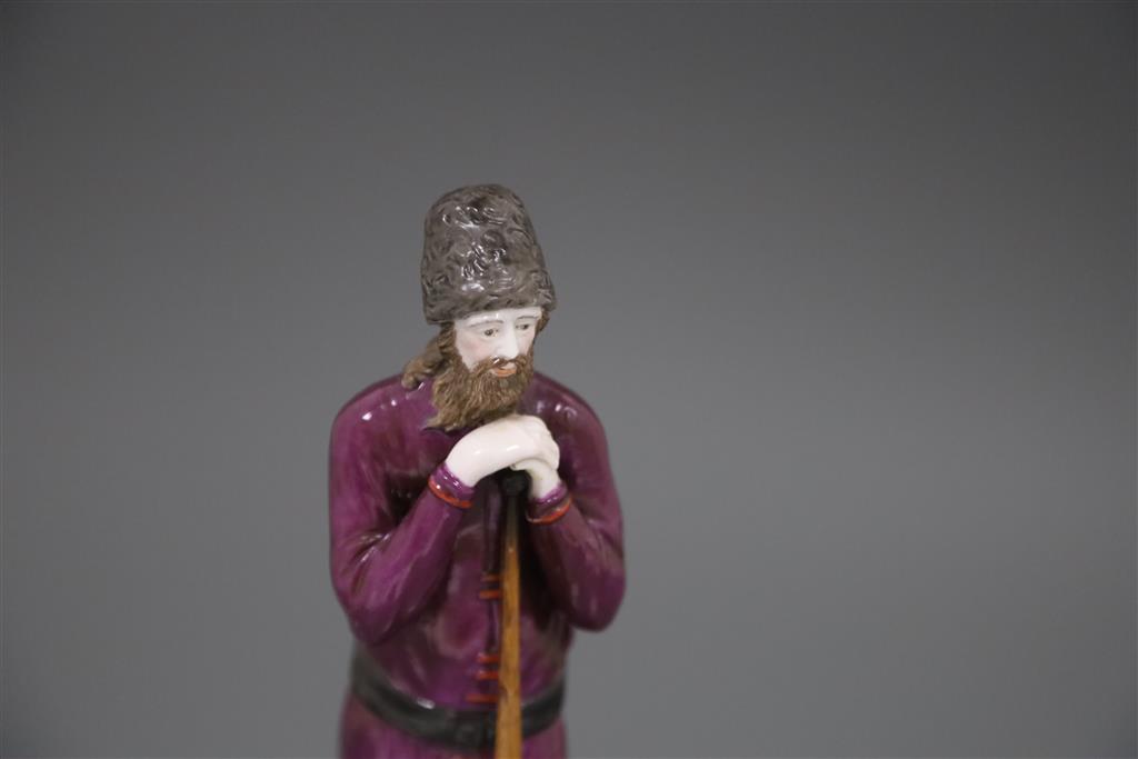 A Russian Gardner porcelain figure of a man holding a staff, mid 19th century, H.21.4cm, loss to left hand and replacement staff